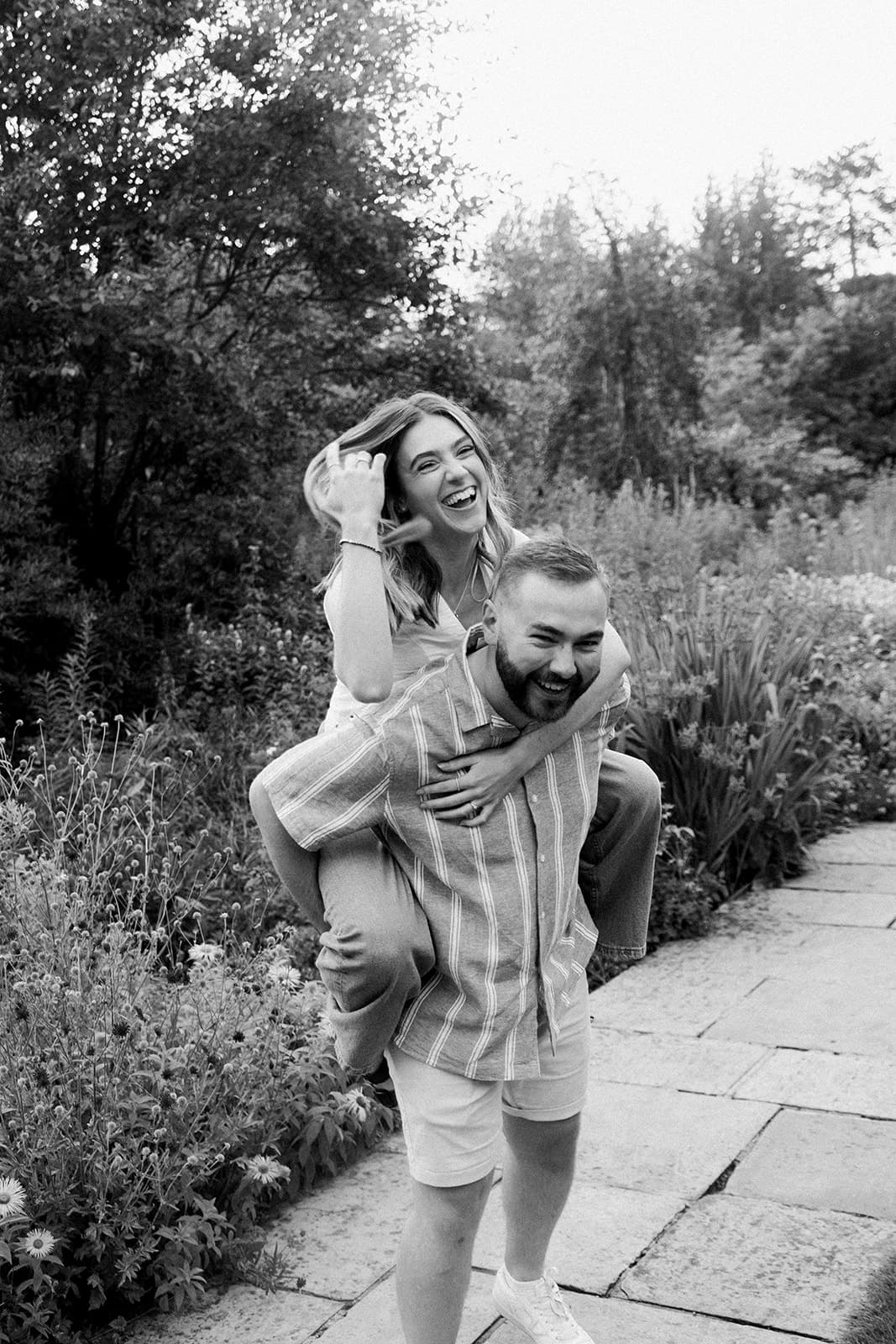 Two people embracing in a garden, image in black and white.