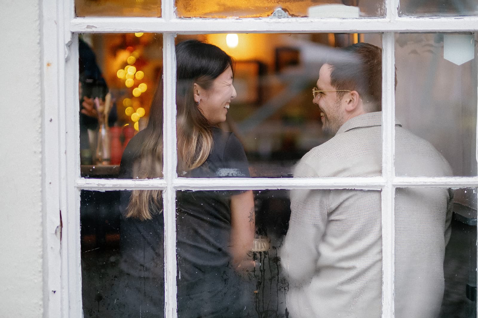 Two people at a window at the ostrich, bristol with warm indoor lights.