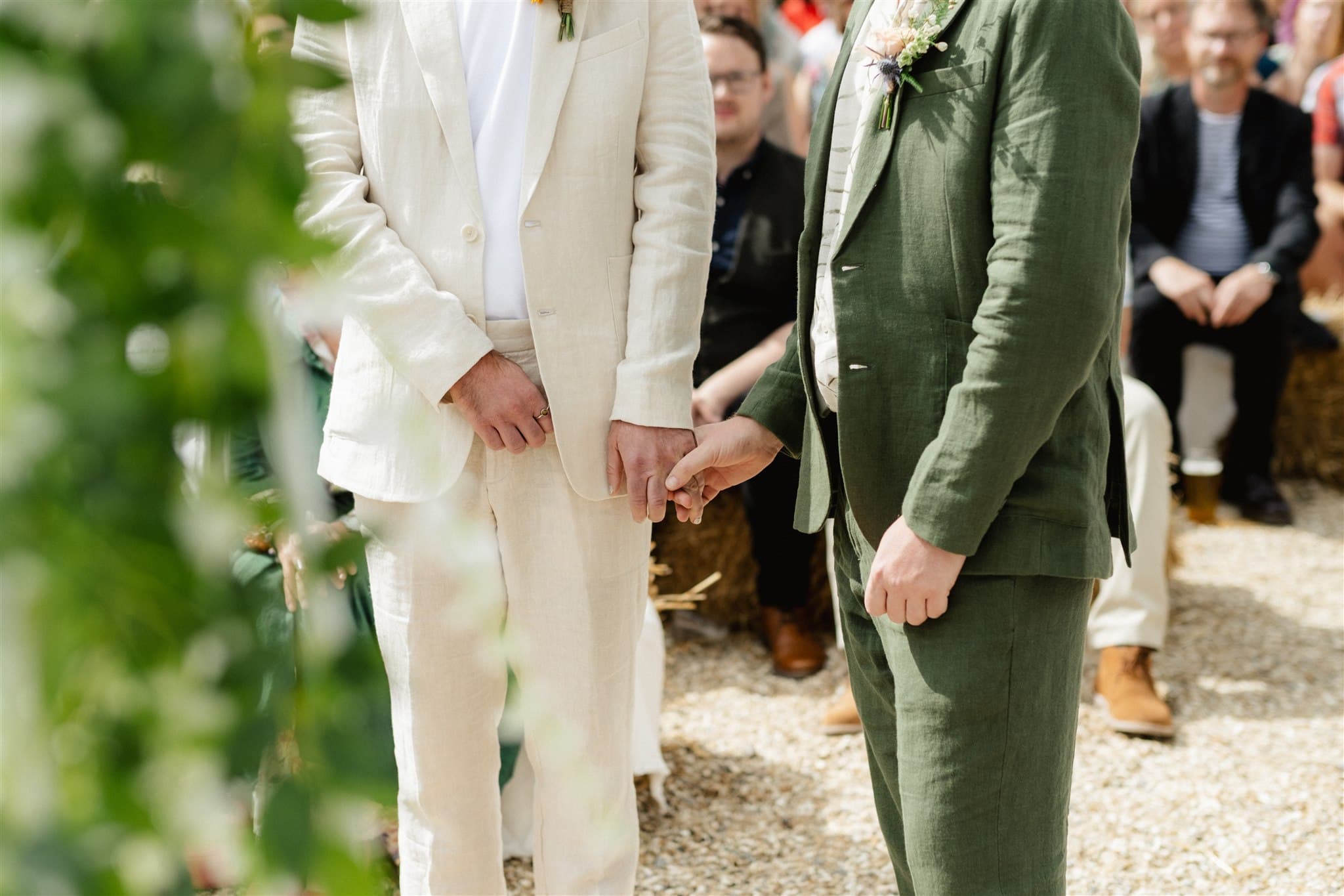 Two people in wedding attire holding hands at a ceremony.
