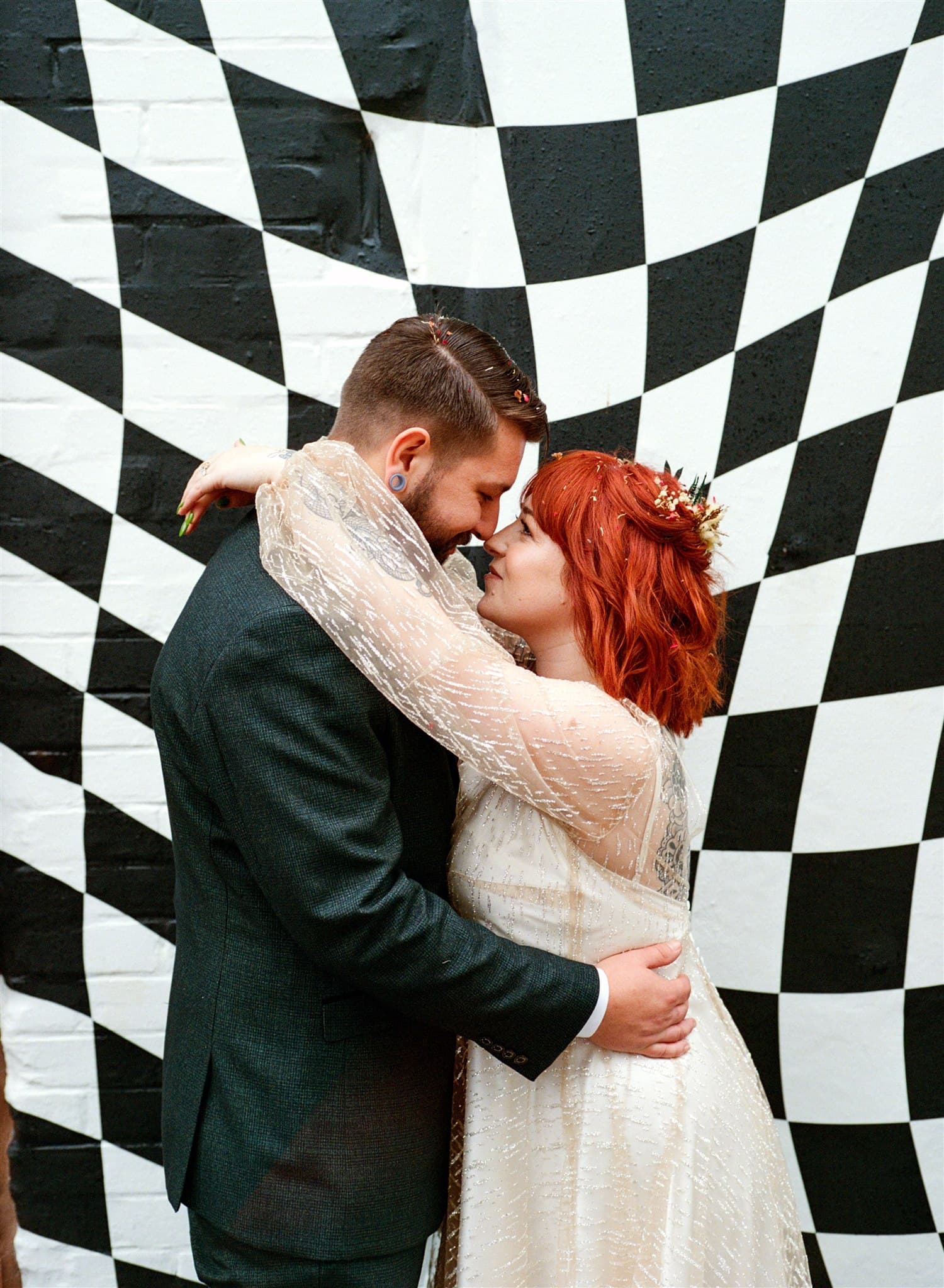 Film photo of the couple in front of checkerboard wall ceremony and the shack revolution