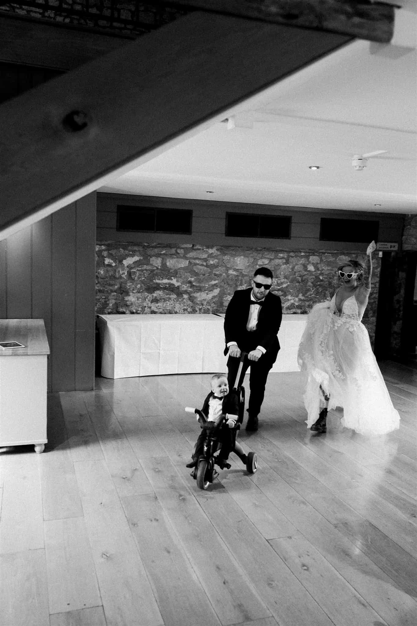 An epic entrance of bride, groom and their child photographed by Ivy and Pine at Priston Mill.